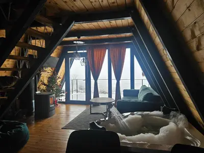 a living room with a couch and a large window at Under Sky House - Vikendica - Manjača in Ključ