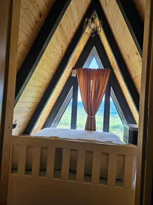 a bedroom in a tree house with a window at Under Sky House - Vikendica - Manjača in Ključ