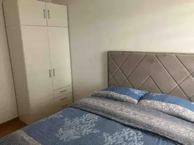 a bedroom with a bed and a white cabinet at Apartman Vrbas 1 + Podzemna garaza in Banja Luka