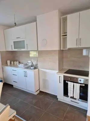 a kitchen with white cabinets and a sink and a stove at Apartman Vrbas 1 + Podzemna garaza in Banja Luka