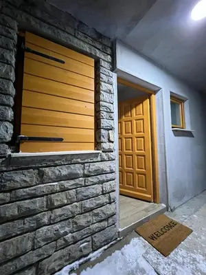 a garage with a stone wall and a door at Villa Dejana Vlašić in Šišava