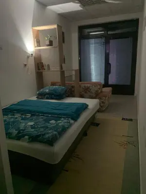 a bedroom with a bed and a living room at Smjestaj in Doboj