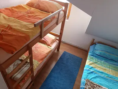 a bedroom with two bunk beds and a blue rug at Vlašić, Babanovac, vikendica Ante in Vlasic