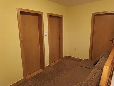 an empty room with two doors and a bed at Vlašić, Babanovac, vikendica Ante in Vlasic