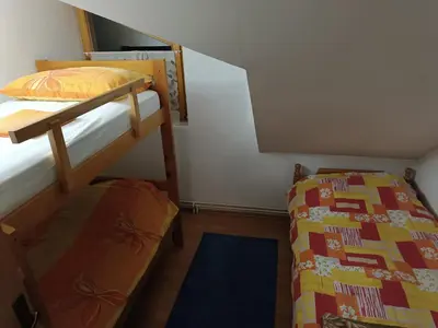 a small room with two bunk beds and a rug at Vlašić, Babanovac, vikendica Ante in Vlasic
