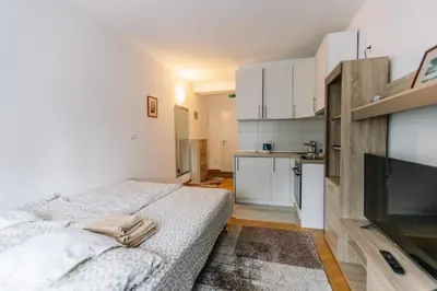 a small bedroom with a bed and a kitchen at Studio Apartmani Donnie in Livno