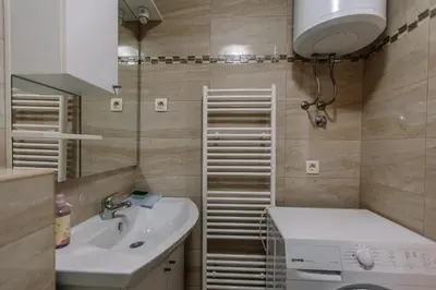 a bathroom with a sink and a washing machine at Studio Apartmani Donnie in Livno