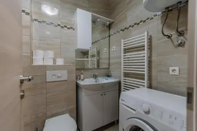 a small bathroom with a washing machine and a washer at Studio Apartmani Donnie in Livno