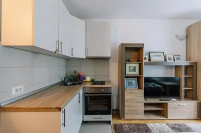 a small kitchen with white cabinets and a television at Studio Apartmani Donnie in Livno