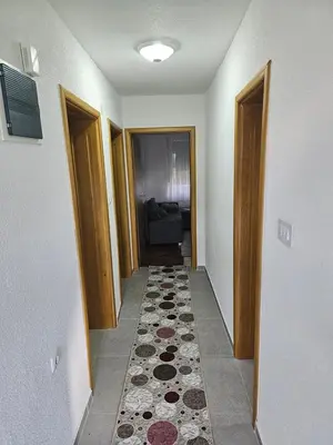 a hallway with several doors and a rug on the floor at Apartman Capital Novi Grad in Bosanski Novi