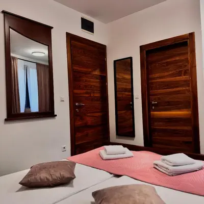 a bedroom with two doors and two towels on a bed at Hotel Paviljon in Bihać
