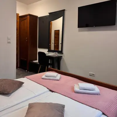 a bedroom with two beds with towels on them at Hotel Paviljon in Bihać
