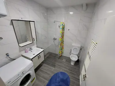 a bathroom with a sink and a toilet and a mirror at Lilly Apartment Tuzla in Tuzla