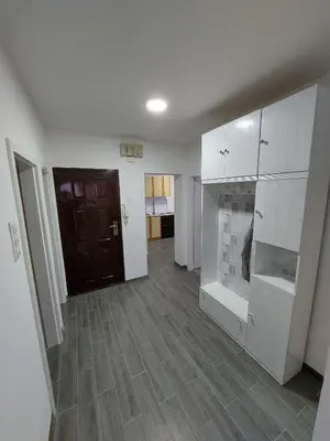 an empty living room with white cabinets and wood flooring at Lilly Apartment Tuzla in Tuzla