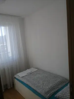 a small bed in a room with a window at Apartman D&D in Banja Luka