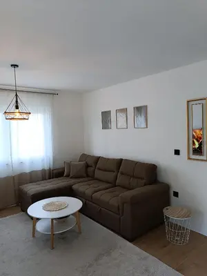 a living room with a couch and a table at Zen Apartment Tuzla in Tuzla