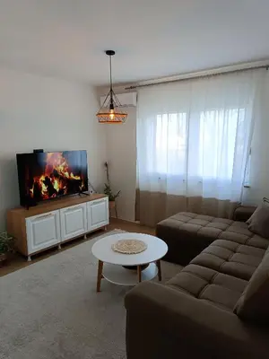 a living room with a couch and a tv at Zen Apartment Tuzla in Tuzla