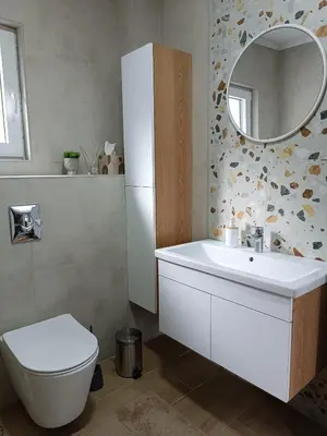 a bathroom with a sink and a toilet and a mirror at Zen Apartment Tuzla in Tuzla