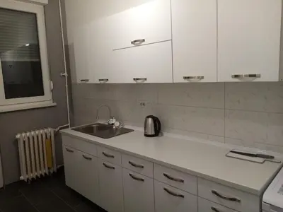 a kitchen with a sink and white cabinets at Apartman Ćetojević in Banja Luka