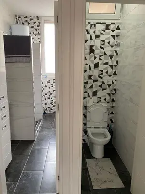 a bathroom with a toilet and a tile wall at Apartman Ćetojević in Banja Luka
