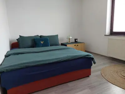 a bedroom with a large bed with blue pillows at Apartmani Marin in Kupres