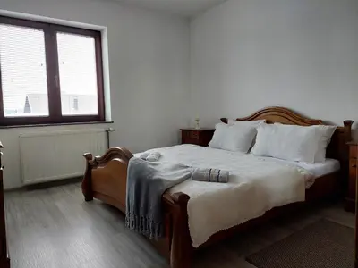 a bedroom with a bed with white sheets and a window at Apartmani Marin in Kupres