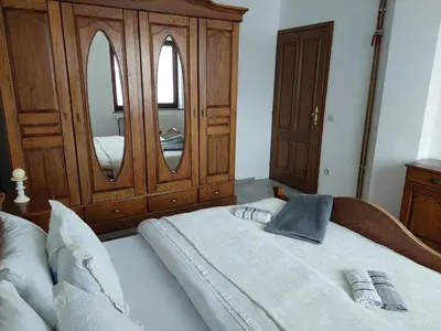a bedroom with a bed with a dresser and a mirror at Apartmani Marin in Kupres