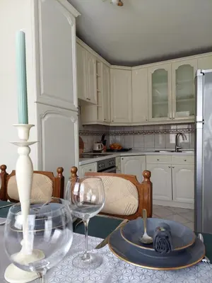 a kitchen with white cabinets and a table with wine glasses at Apartmani Marin in Kupres