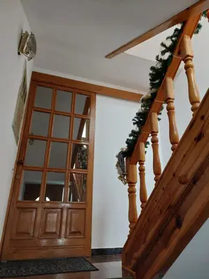 a staircase with a wooden door with a christmasreath at Apartmani Marin in Kupres