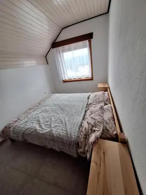 a bed in a small room with a window at Apartmani 