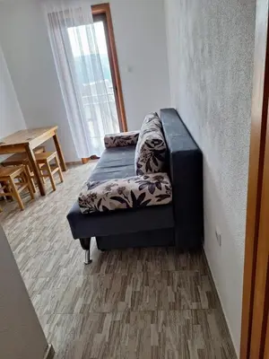 a couch sitting in a room with a table at Apartmani 