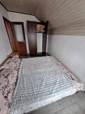 a large bed in a room with a wooden ceiling at Apartmani 