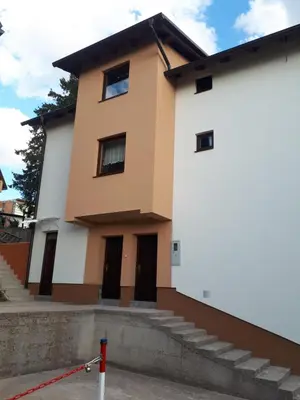 a house with white walls and brown doors at Apartmani 