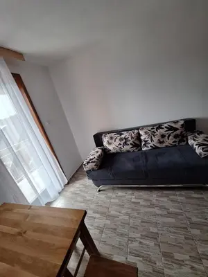 a black couch in a living room with a table at Apartmani 