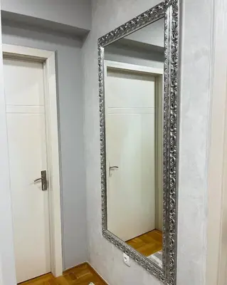 a mirror with a silver frame on a wall at Apartman Central in Banja Luka