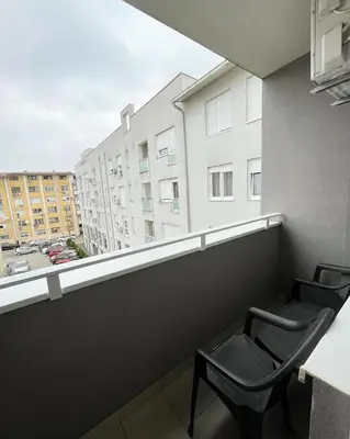 two chairs on a balcony with a view of a building at Apartman Central in Banja Luka
