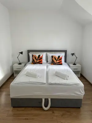 a bedroom with a large white bed with two lamps at Apartman Dolly Bell in Kotor-Varoš