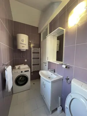 a bathroom with a washing machine and a sink at Apartman Dolly Bell in Kotor-Varoš