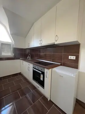a kitchen with white cabinets and a stove top oven at Apartman Dolly Bell in Kotor-Varoš