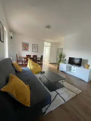 a living room with a black couch and a table at Apartman Dolly Bell in Kotor-Varoš