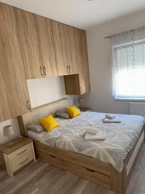 a bedroom with a large bed with yellow pillows at MARICELO in Banja Luka