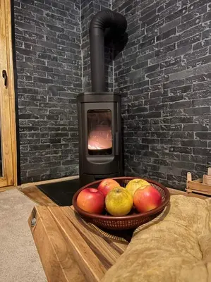 a bowl of apples and pears in front of a stove at Vila Šibovi in Banja Luka