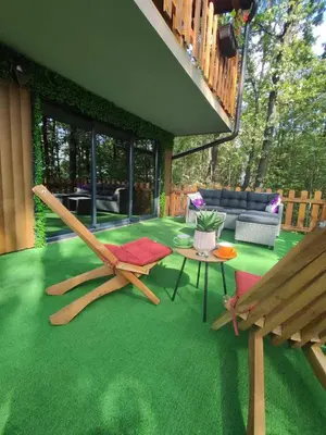 a patio with green grass and a bench and a table at Vila Šibovi in Banja Luka