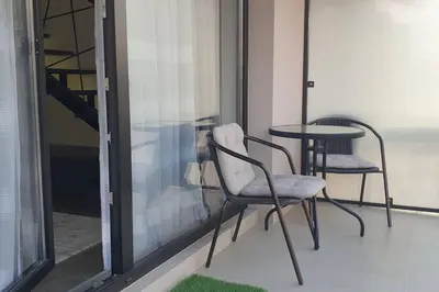 a balcony with two chairs and a table and a window at Urban Maisonette in Banja Luka