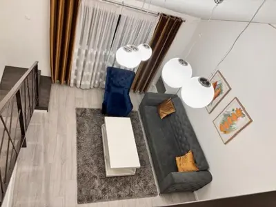 a living room with a couch and blue chairs at Urban Maisonette in Banja Luka