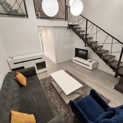 a living room with a couch and a tv at Urban Maisonette in Banja Luka