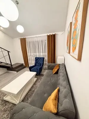 a living room with a couch and a blue chair at Urban Maisonette in Banja Luka