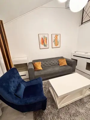 a living room with a couch and a blue chair at Urban Maisonette in Banja Luka