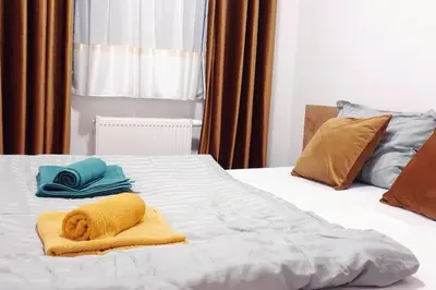 a bed with two towels and two pillows on it at R-RESIDENCY Panorama in Banja Luka