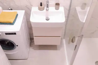 a white bathroom with a sink and a washing machine at R-RESIDENCY Panorama in Banja Luka
